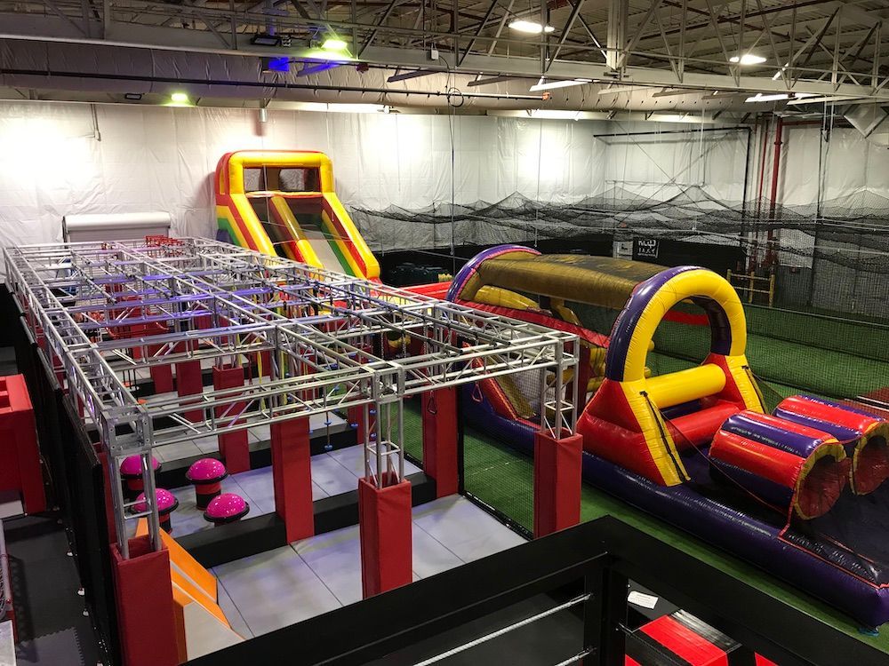 A large inflatable obstacle course in a gym.