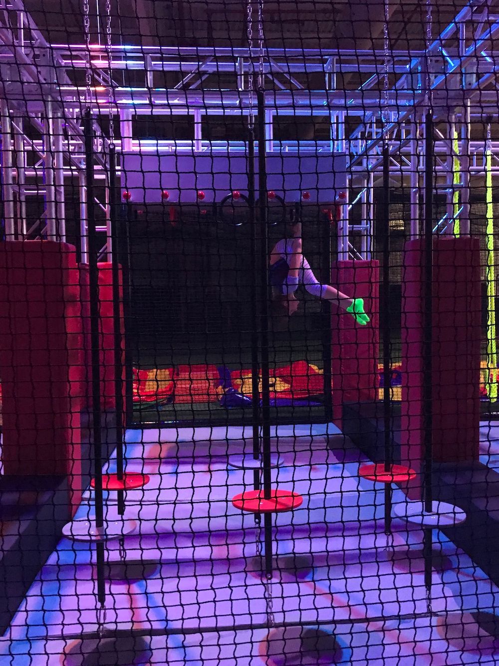 A person is flying through the air in a trampoline park.