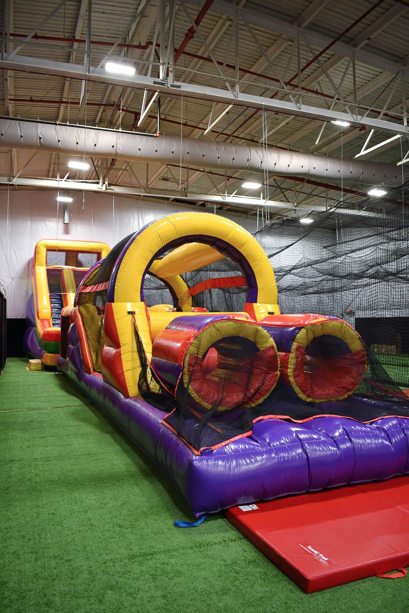 A large inflatable obstacle course in a warehouse.