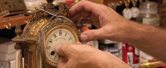 Man hands repairing the antique clock