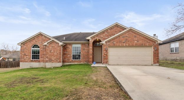 Single-story brick suburban house with attached two-car garage and front lawn