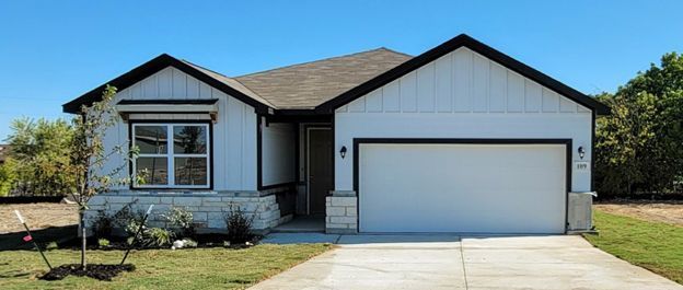 Single-story suburban house with a two-car garage, white siding, and a front lawn.