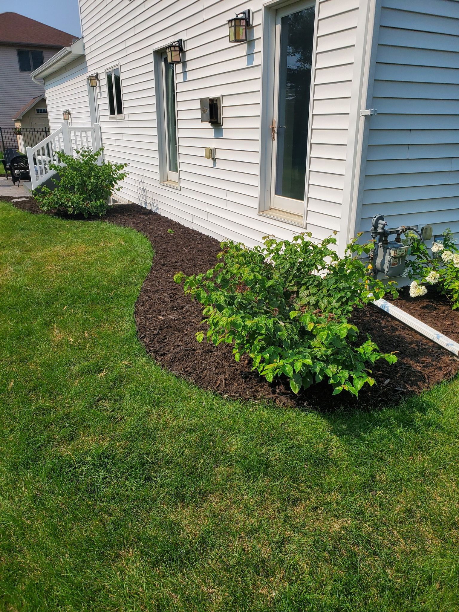 A white house with a lush green lawn in front of it.