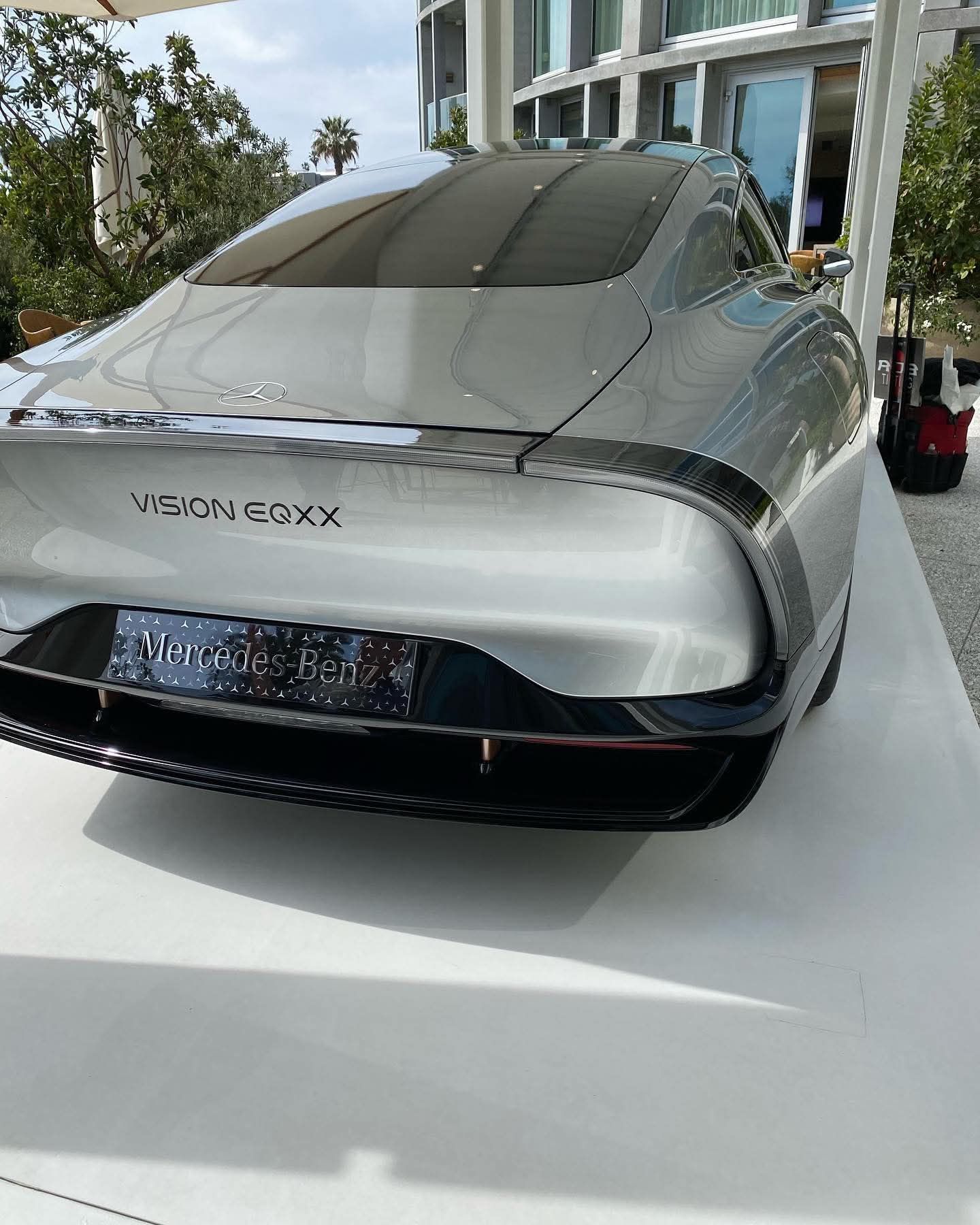 Silver Vision EQXX concept car on display indoors, front view on a white platform.