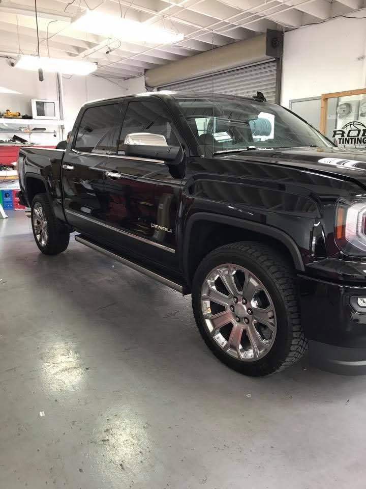 Black pickup truck parked inside a garage or auto shop