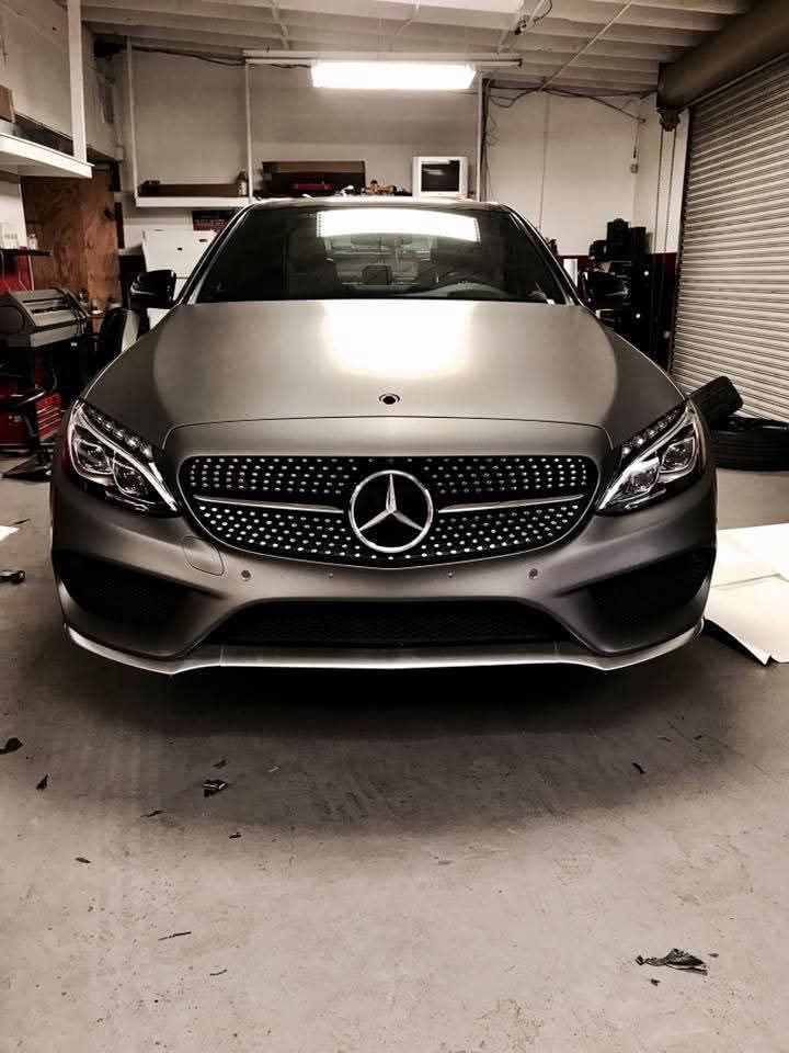 Silver Mercedes-Benz parked in a garage, front view under indoor lighting