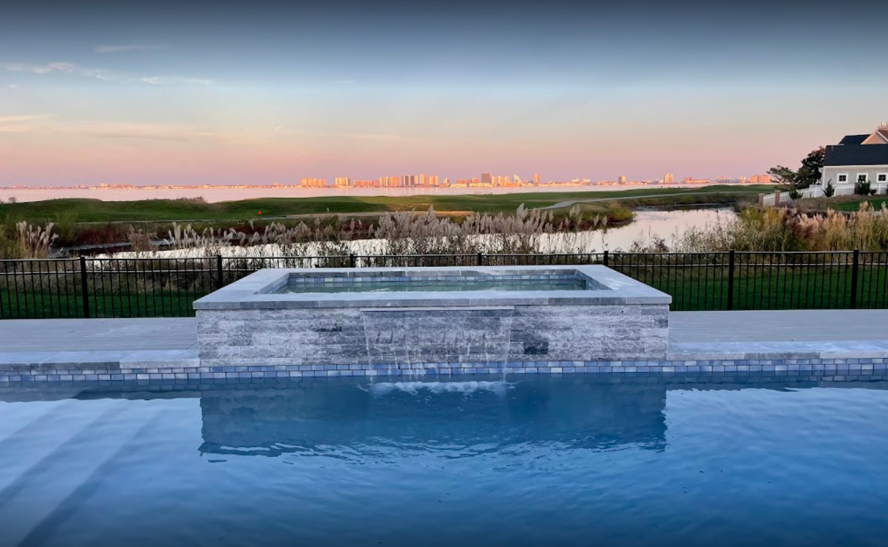 A large swimming pool with a hot tub in the middle of it.