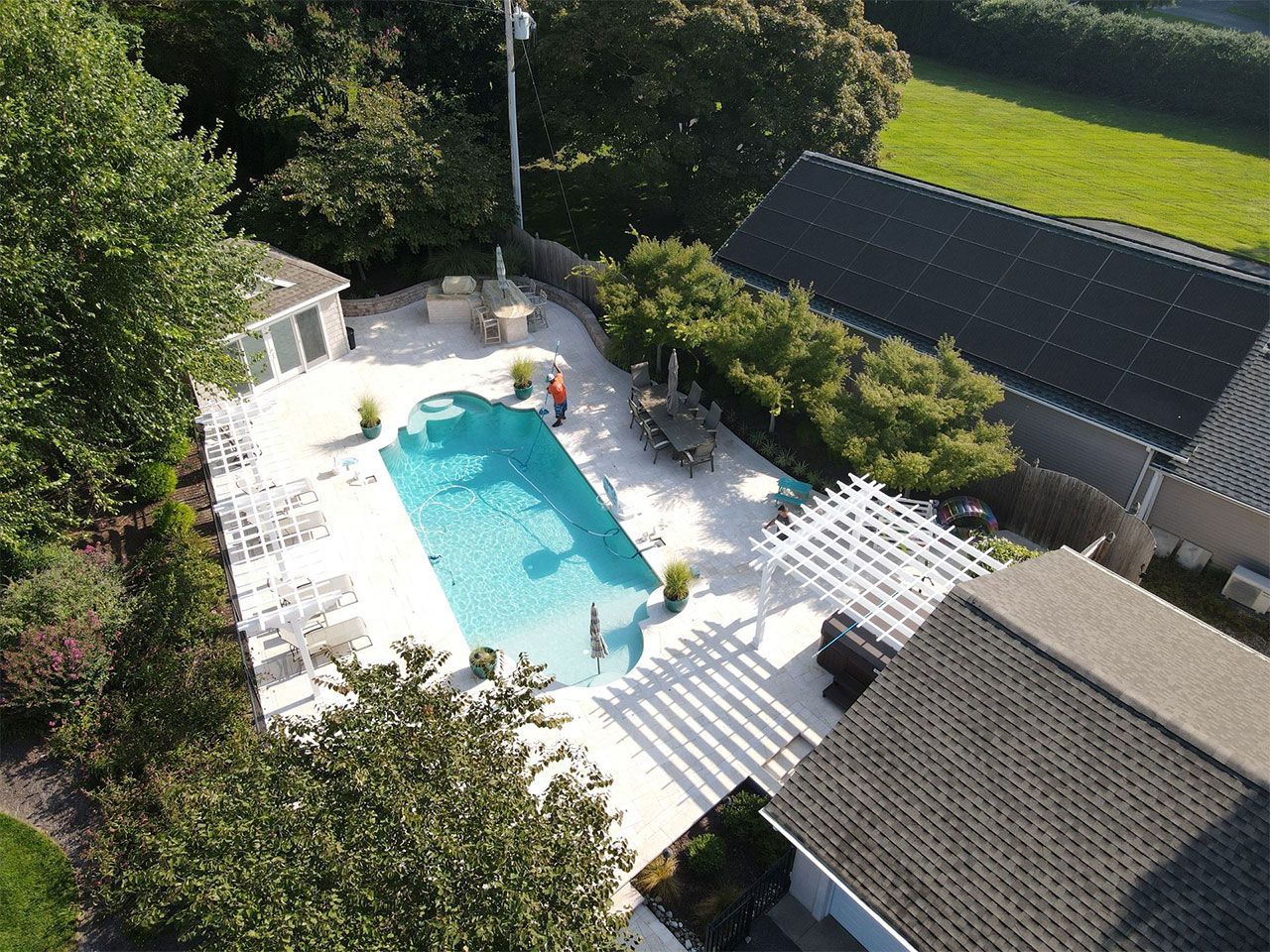 An aerial view of a house with a large swimming pool