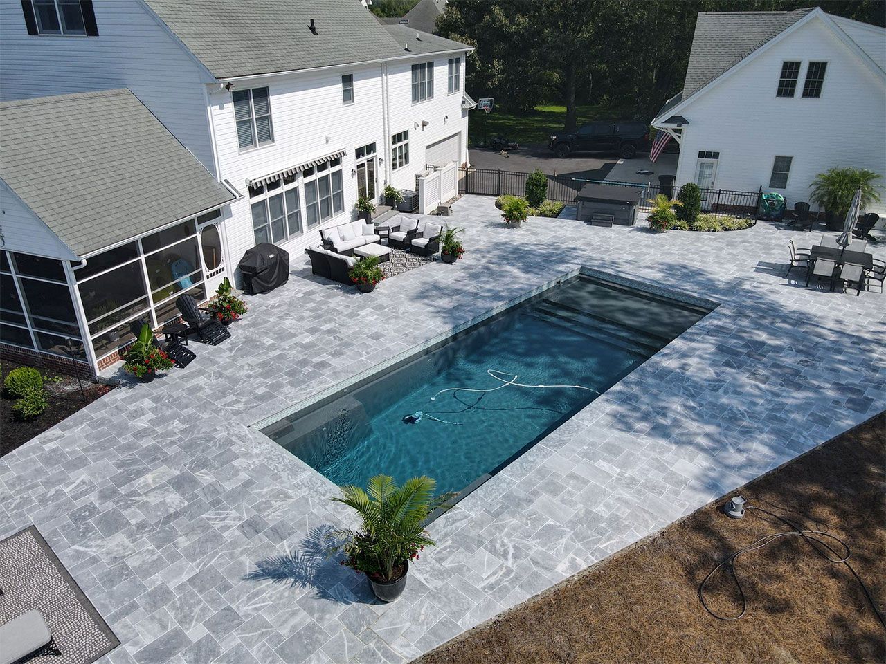 An aerial view of a large swimming pool in the backyard of a house