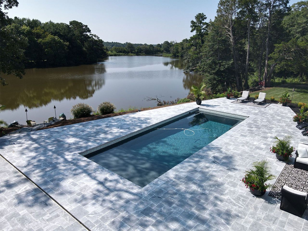 An aerial view of a large swimming pool overlooking a lake