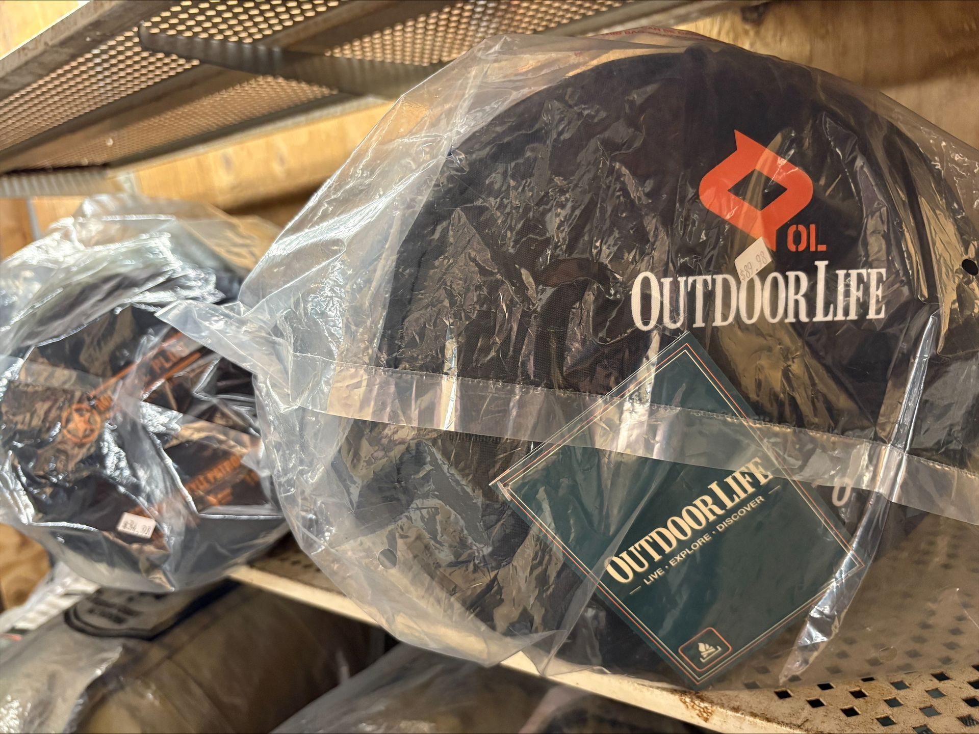 Sleeping bags in plastic wrapping on a shelf; logo reads