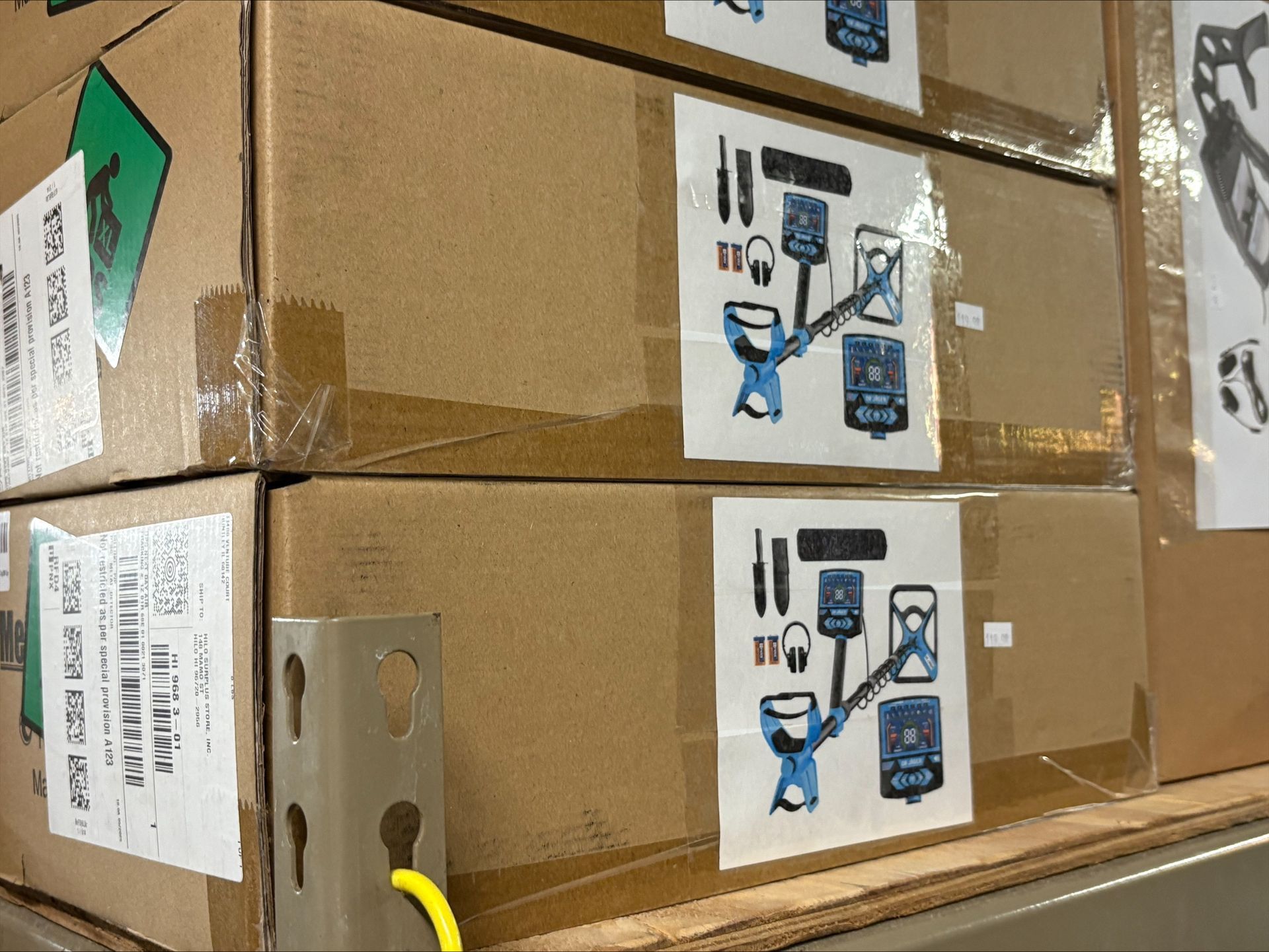 Stacked cardboard boxes with product stickers, in a warehouse setting.