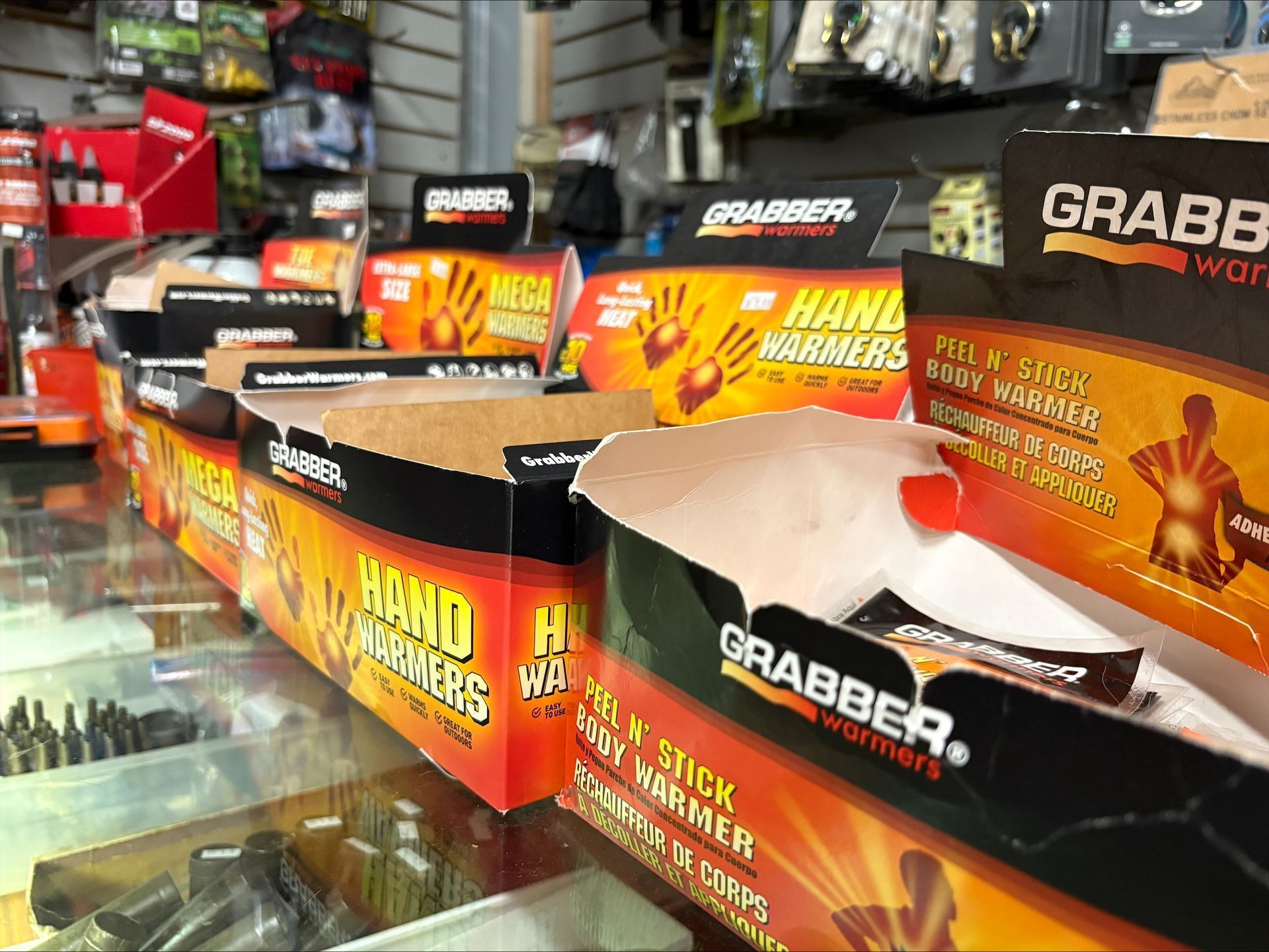 Display of Grabber hand and body warmers in a store. Boxes are orange and black.