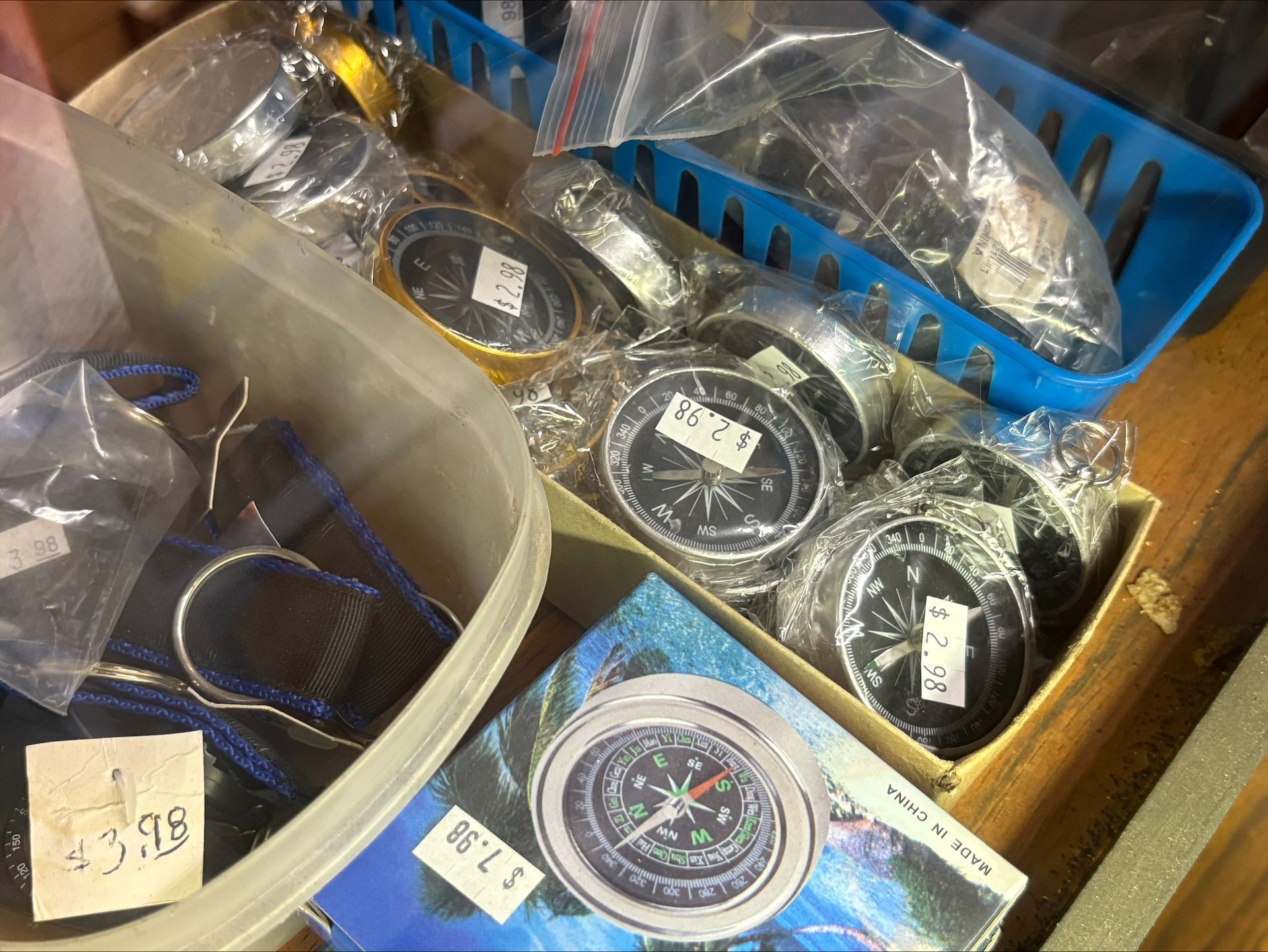 Various compasses for sale in containers.