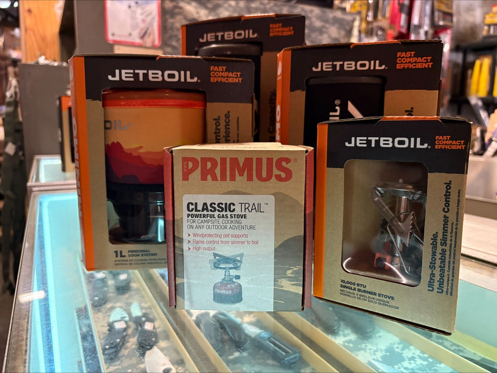 Boxes of Jetboil and Primus camping stoves sit on a display counter in a store.
