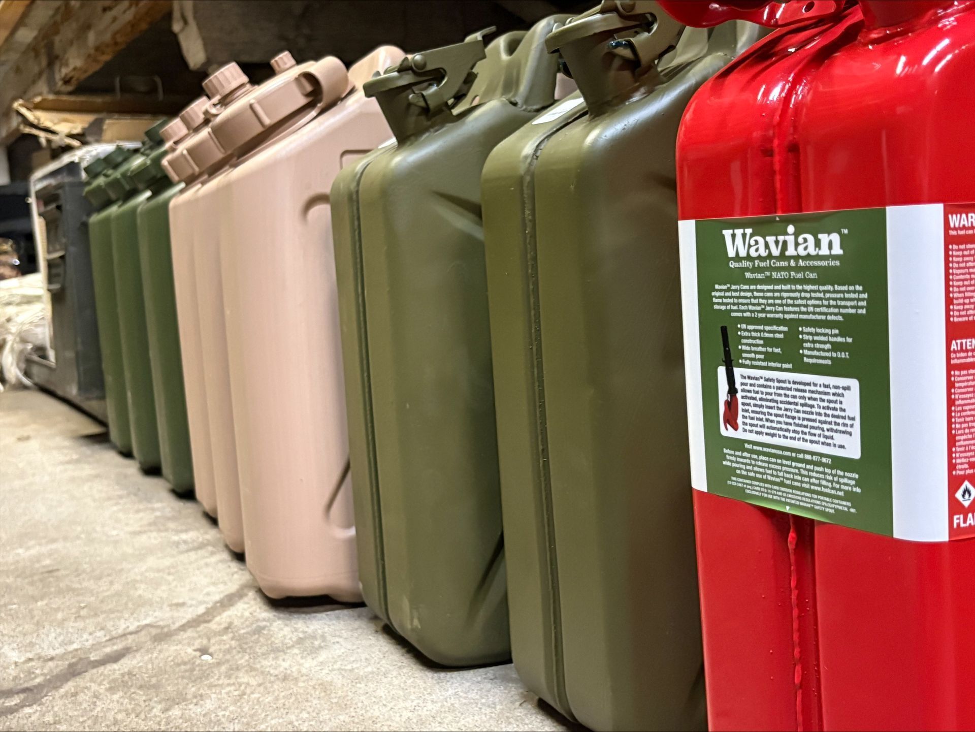 Line of colored fuel or water cans, including red, green, and tan.