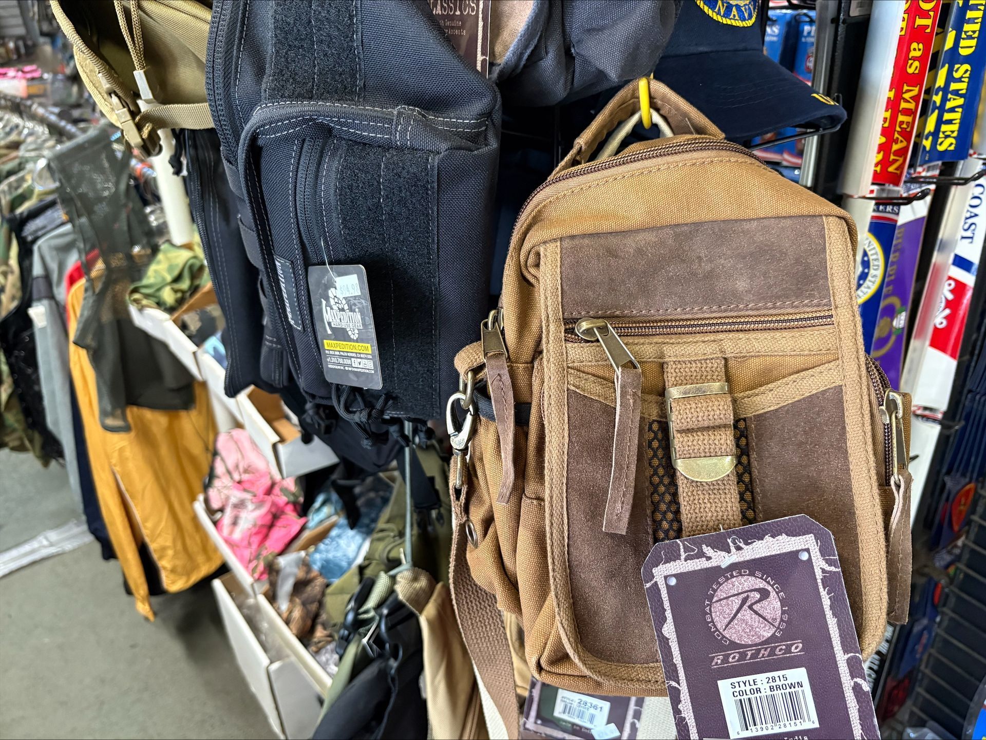 Bags on display at a store, including a brown backpack with a tag.