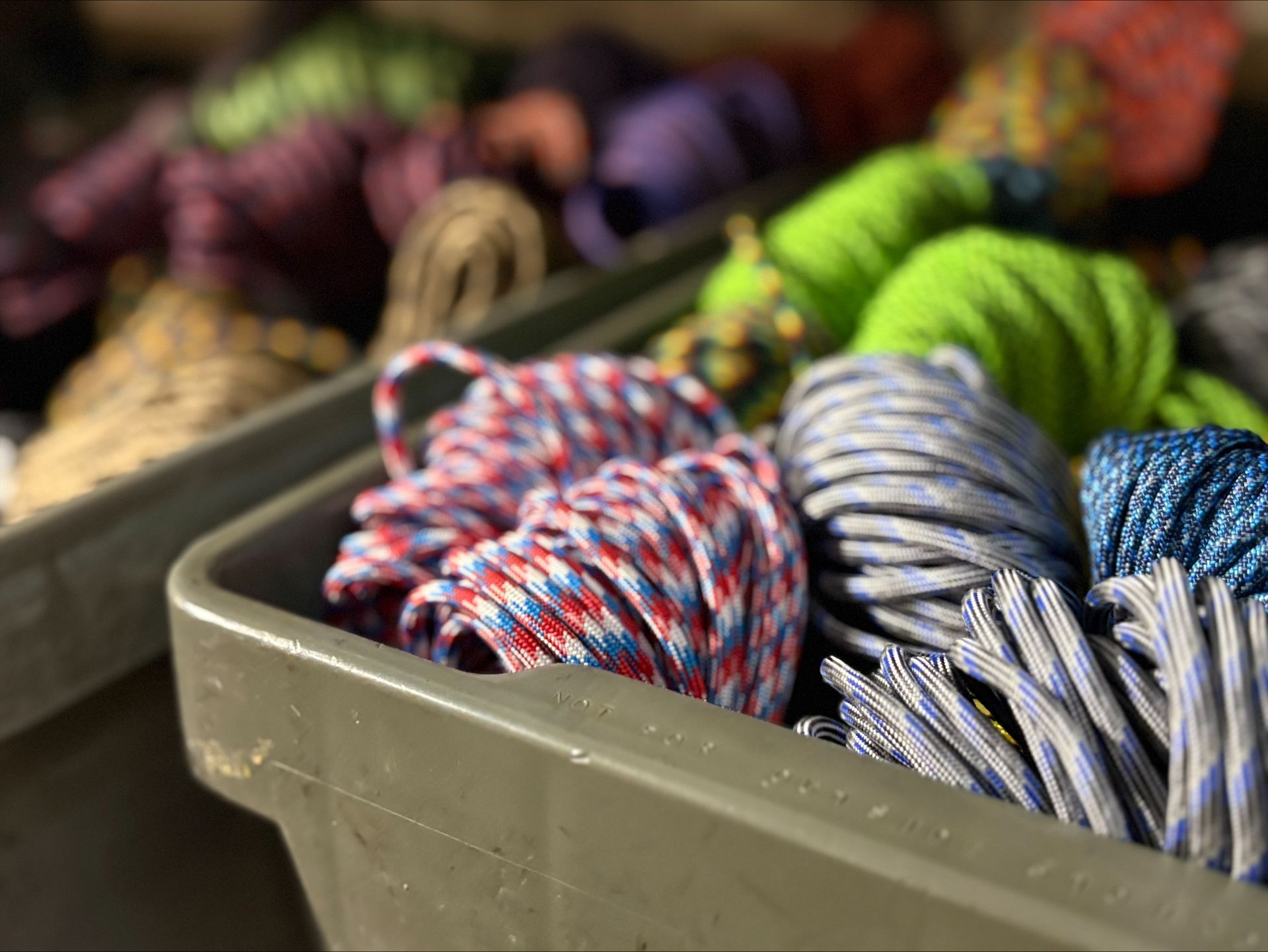 Plastic bins filled with coiled colorful ropes.