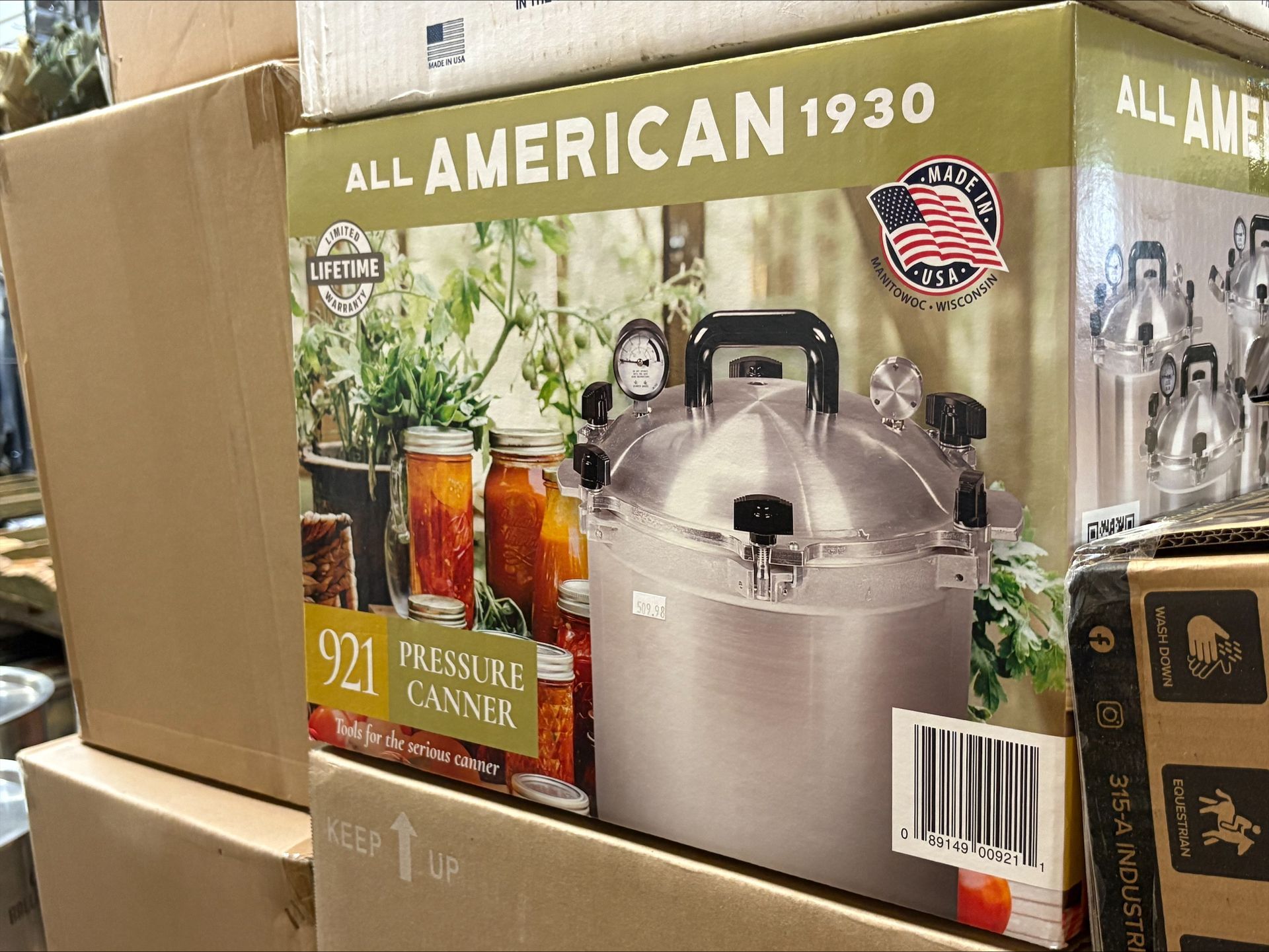 Box for an 'All American 1930' pressure canner, featuring a photo of the canner and canned goods.
