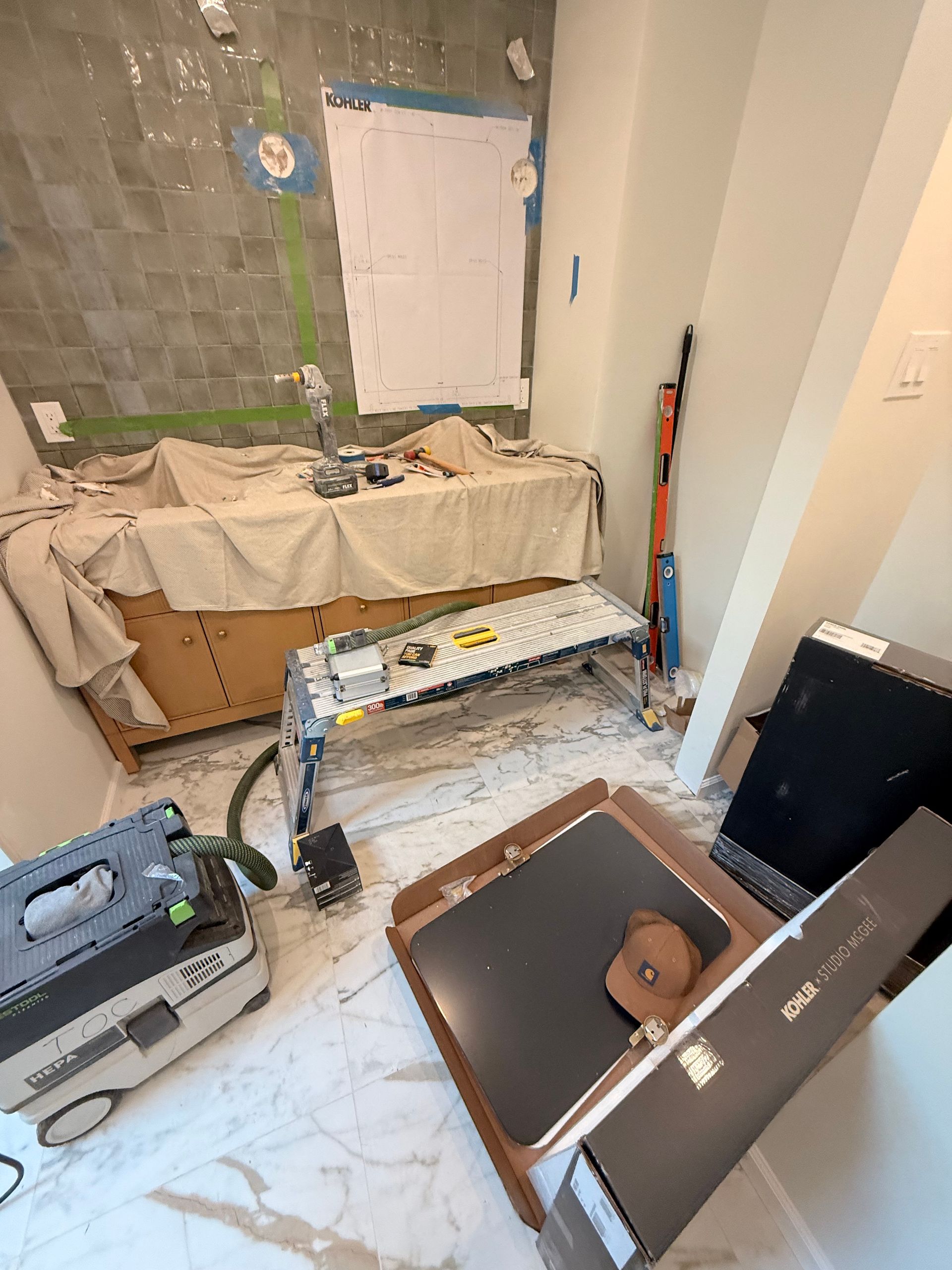 Bathroom under construction with tools and materials scattered around.