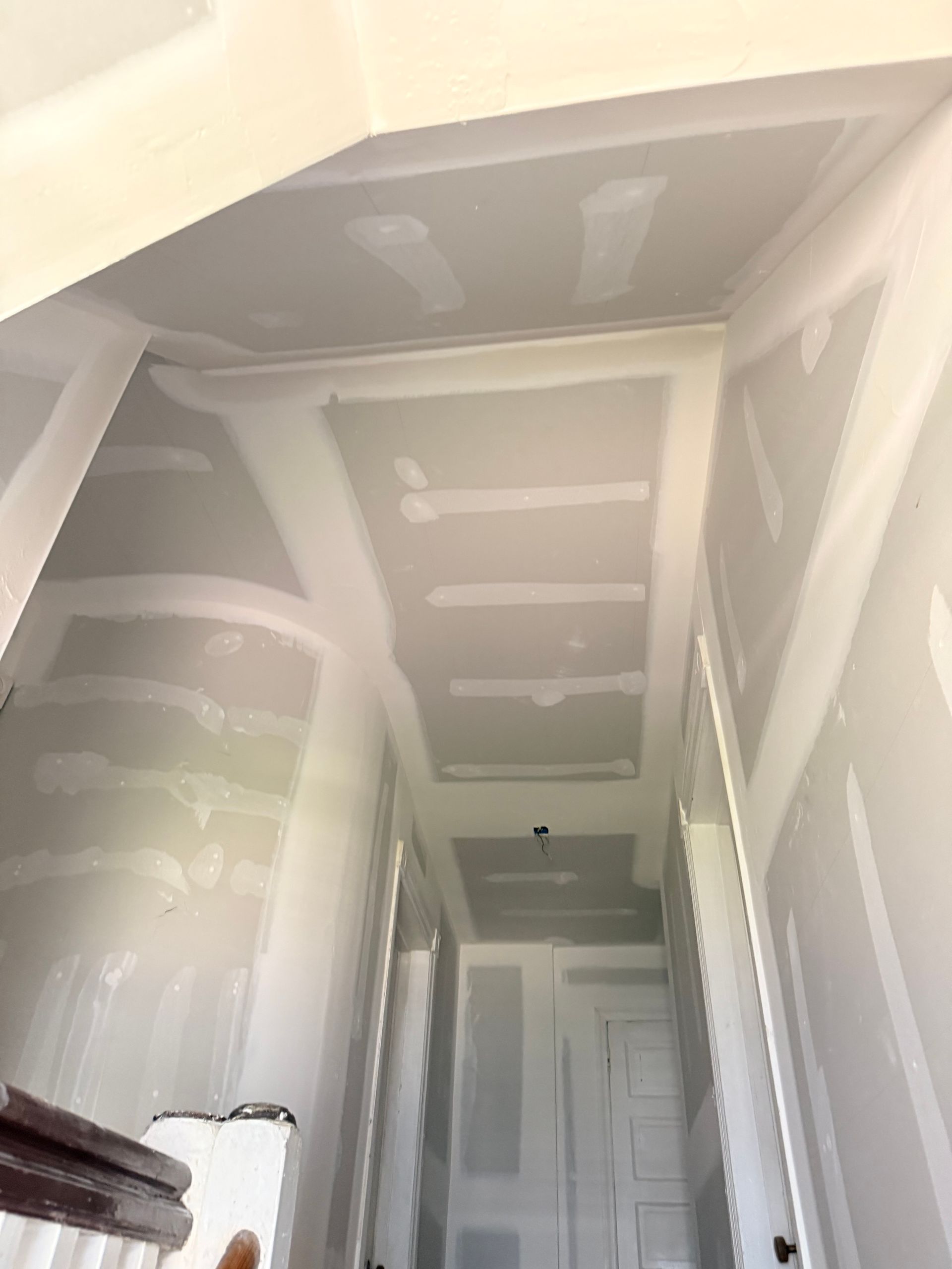 Hallway ceiling with drywall, unfinished construction.