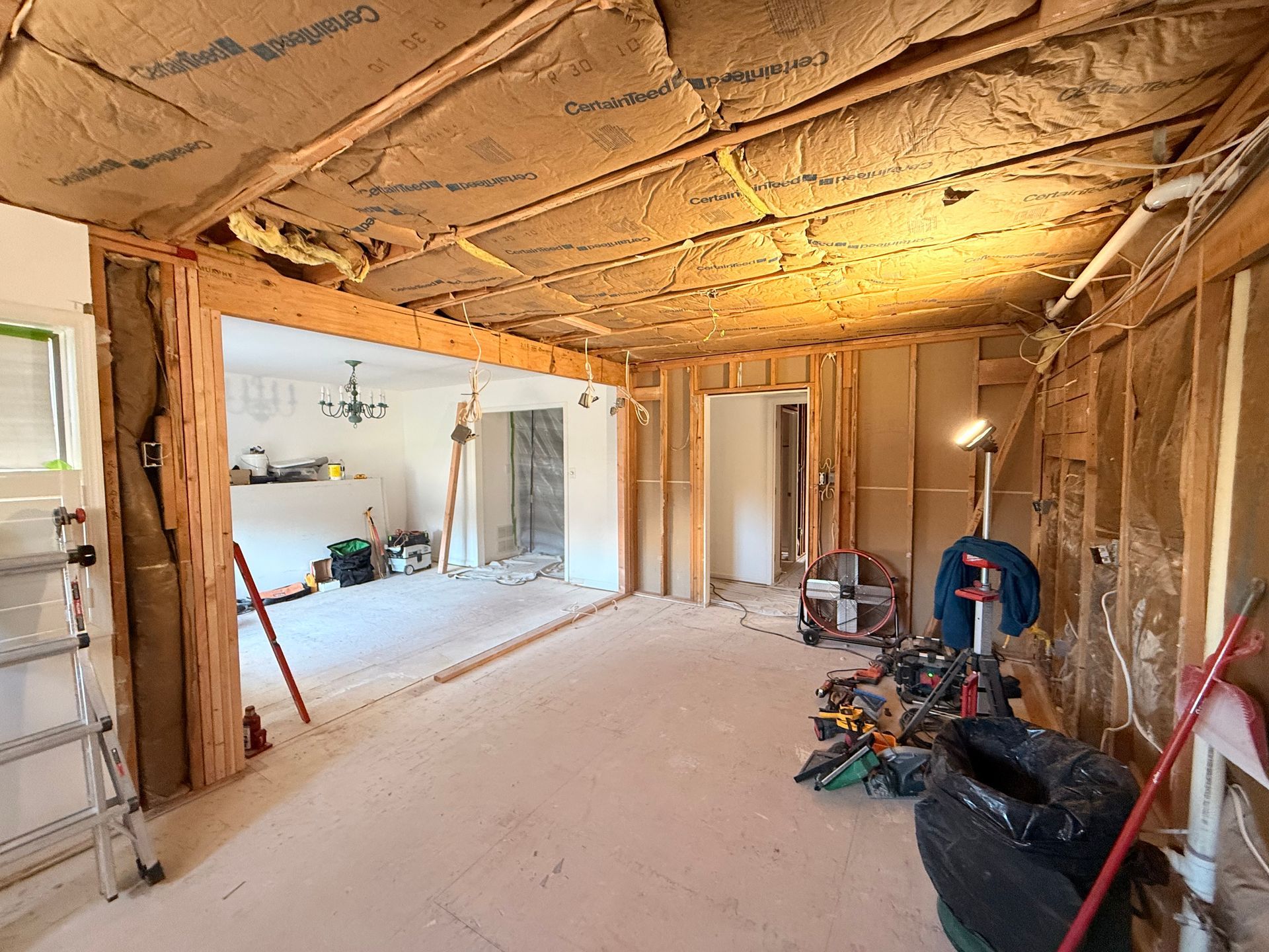 Interior renovation, room with exposed studs, insulation, and tools.