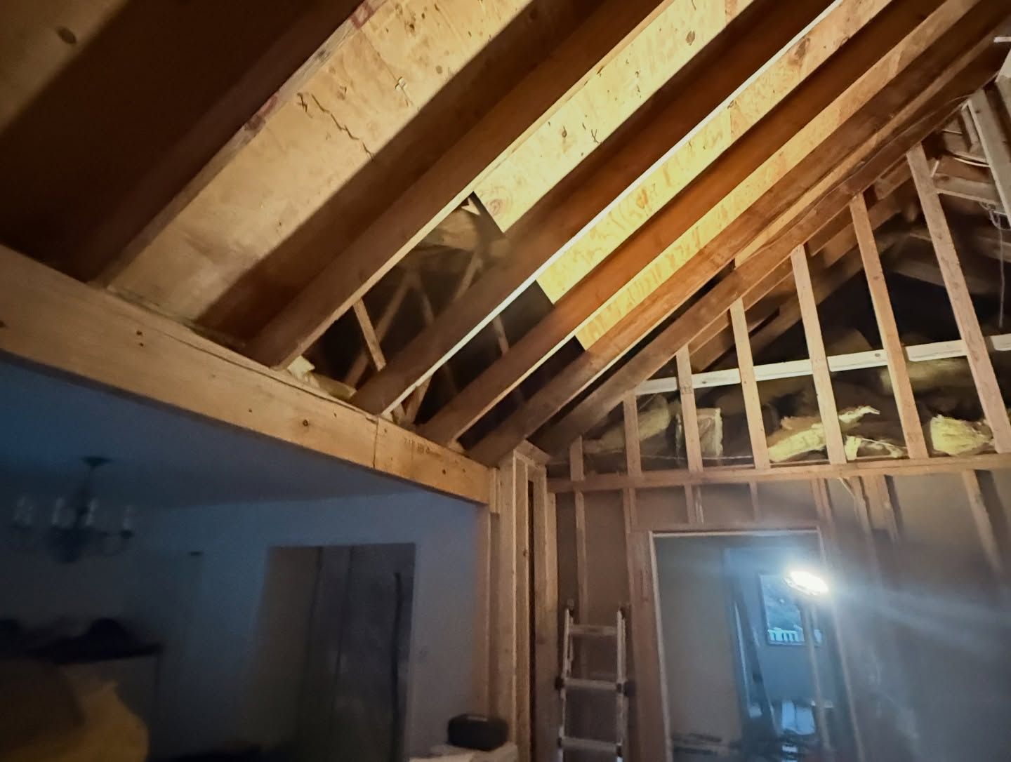 Interior construction: exposed wooden beams and wall framing, partially completed.