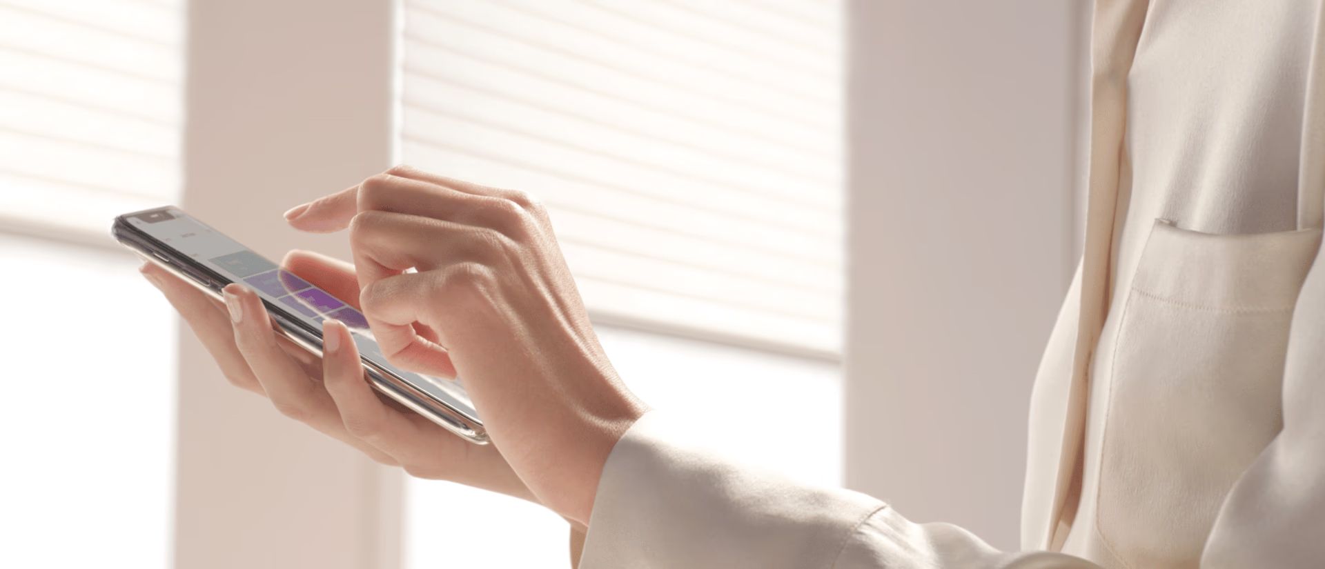 Person using a smartphone near a bright window, tapping the screen with one hand.