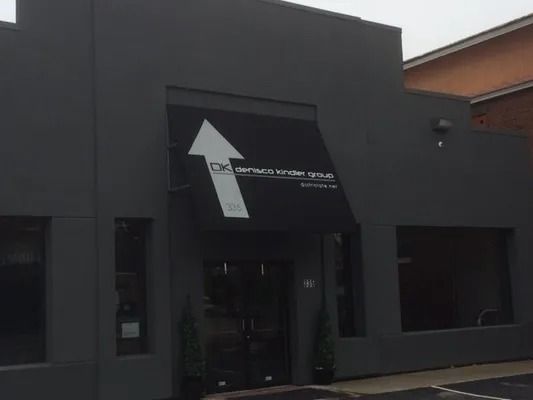 Gray building with a large white arrow over the entrance. 