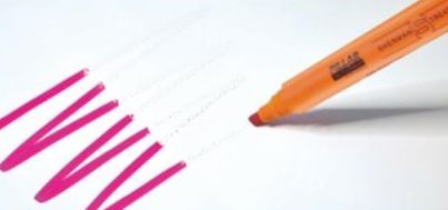 Orange marker highlighting pink checklist marks on white paper.