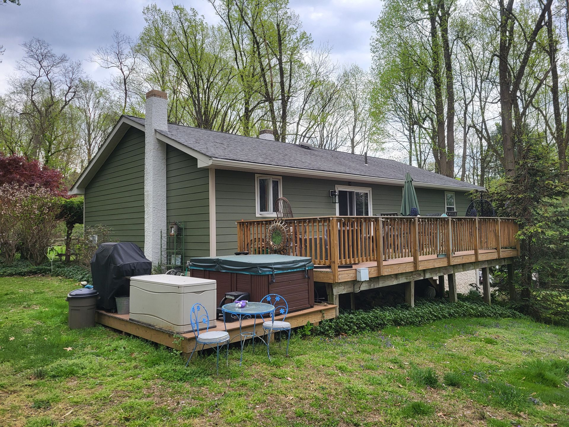 A house with a large deck and a hot tub in the backyard