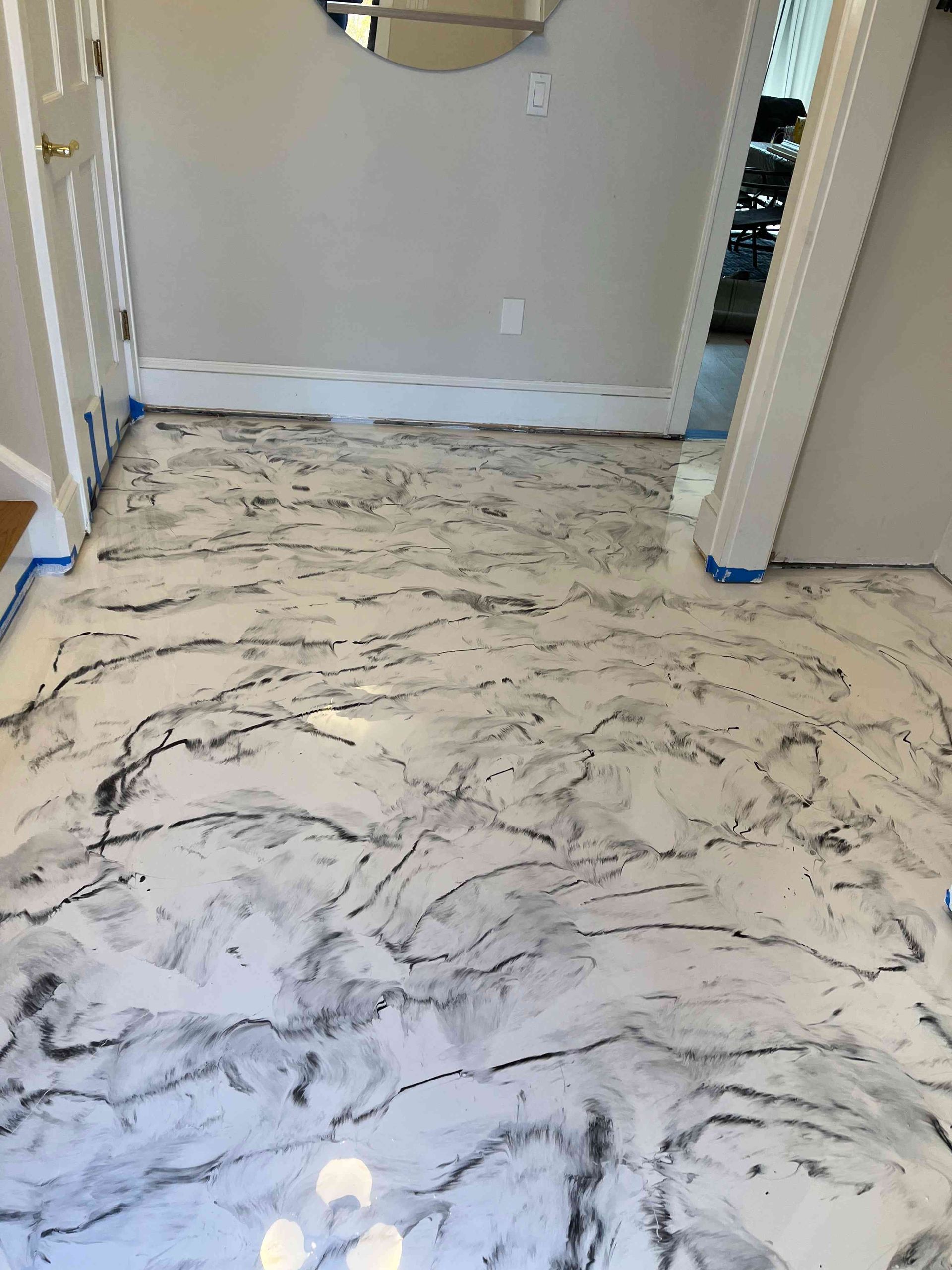 Metallic epoxy floor with marbled appearance in a hallway. White and gray swirls.