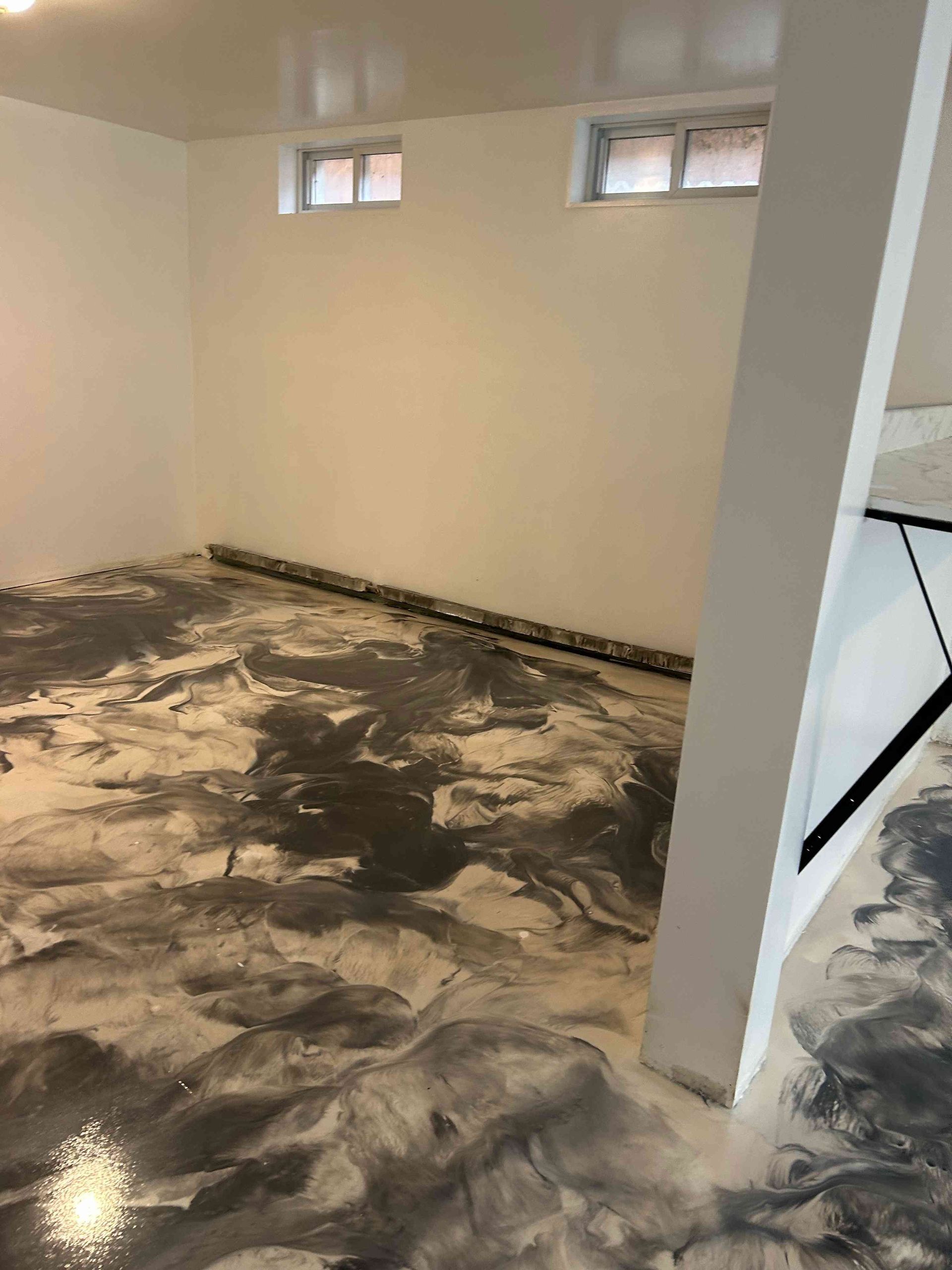 Room with metallic epoxy floor, white walls, two small windows, and a supporting pillar.