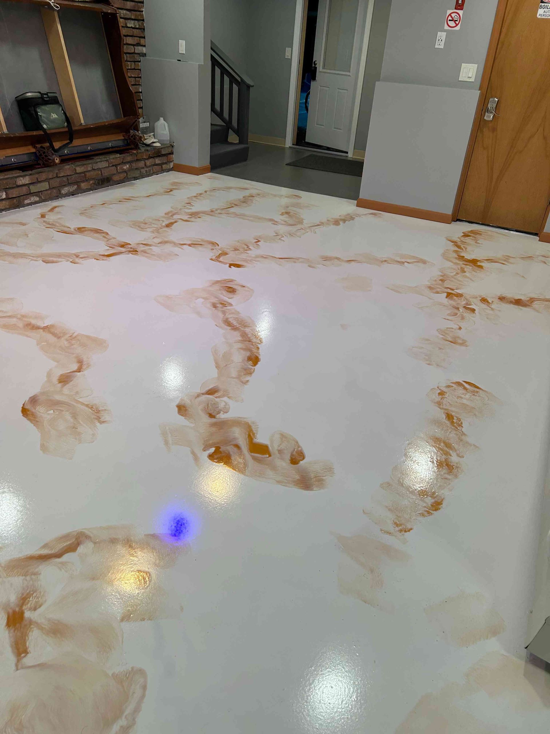 White epoxy floor with brown marble effect.