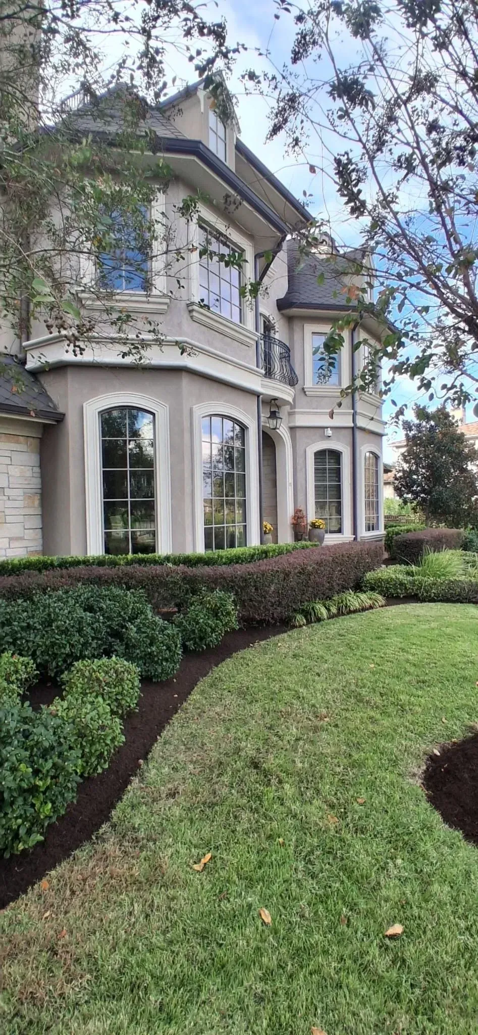 Elegant gray house with manicured lawn and garden.