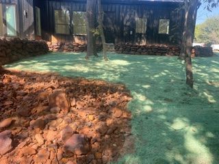 A house with a lot of rocks and grass in front of it.