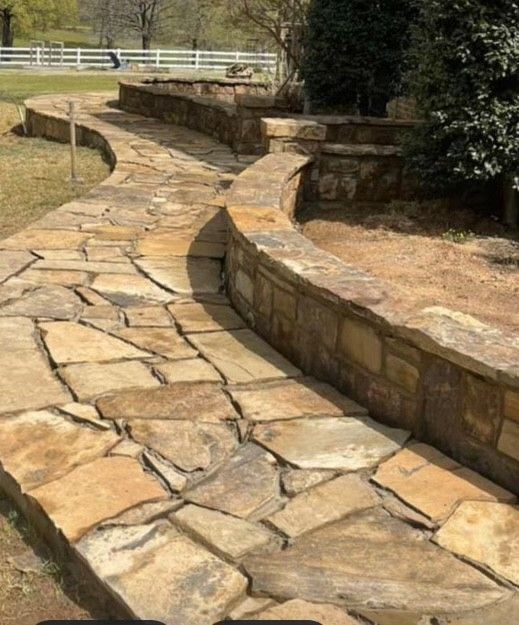 A stone walkway with a stone wall along the side of it.