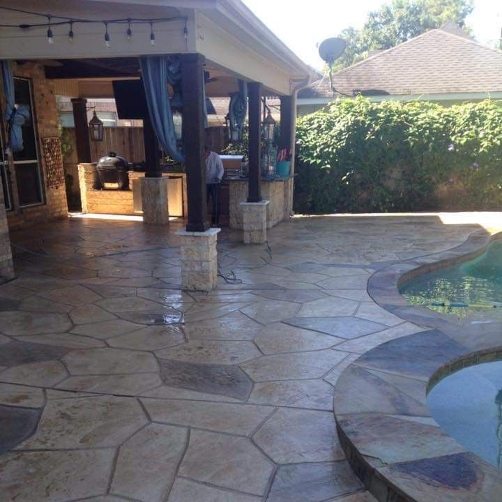 A patio with a swimming pool in the background