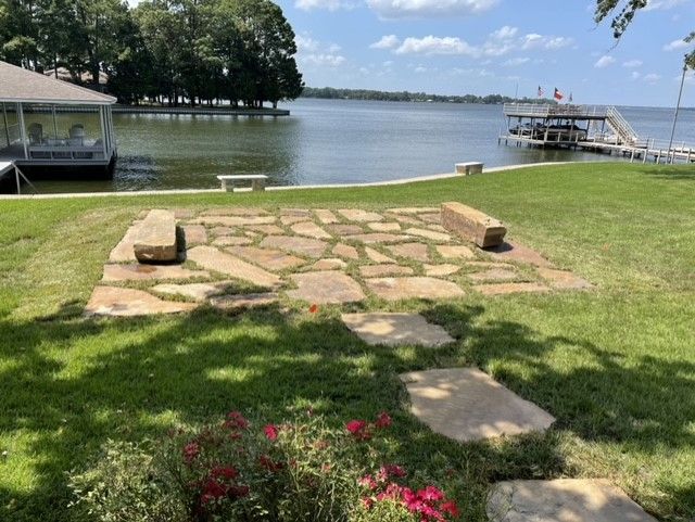 a stone walkway leading to a dock overlooking a lake .