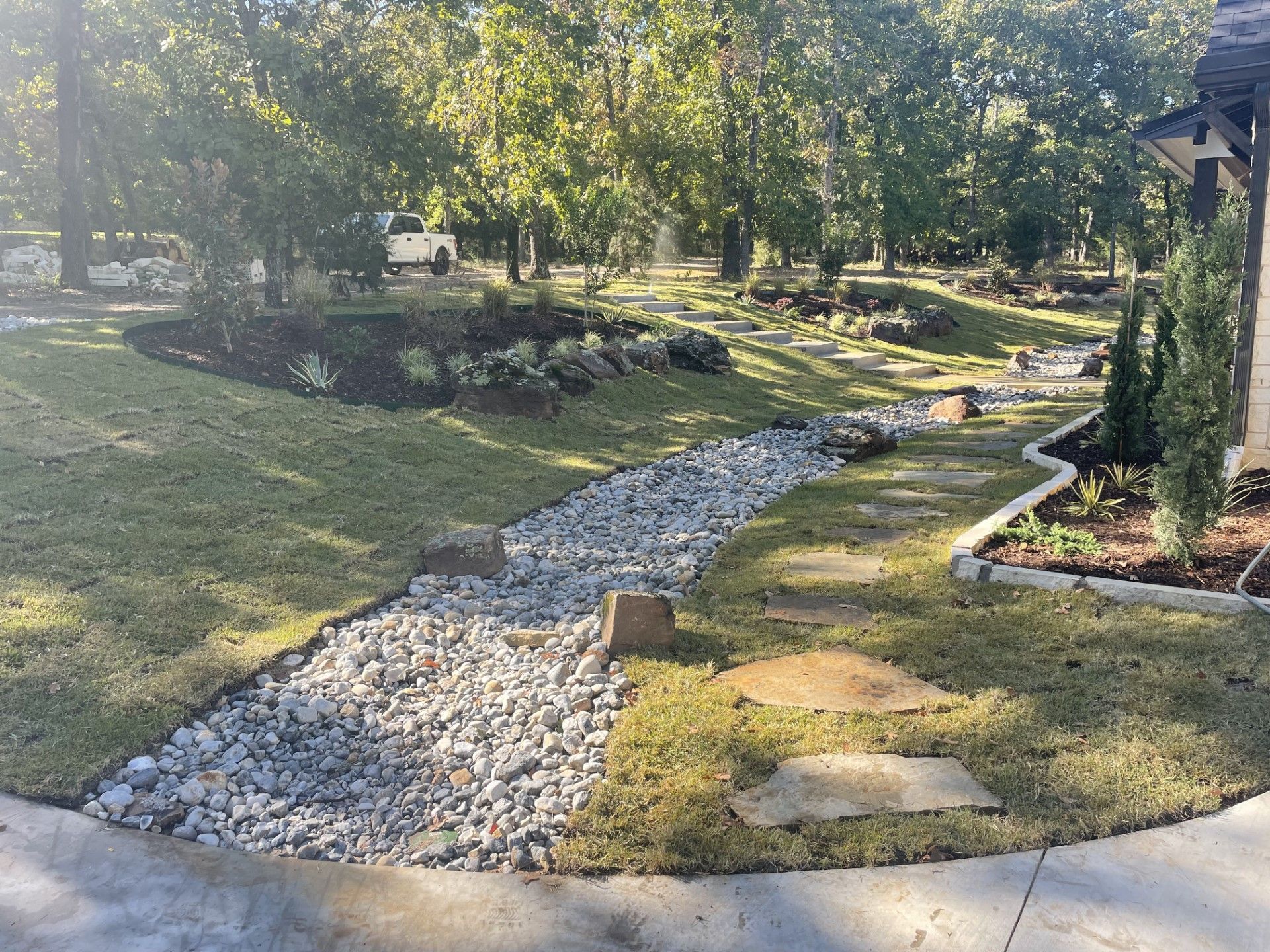 A gravel path leading to a greenhouse in the middle of a field.