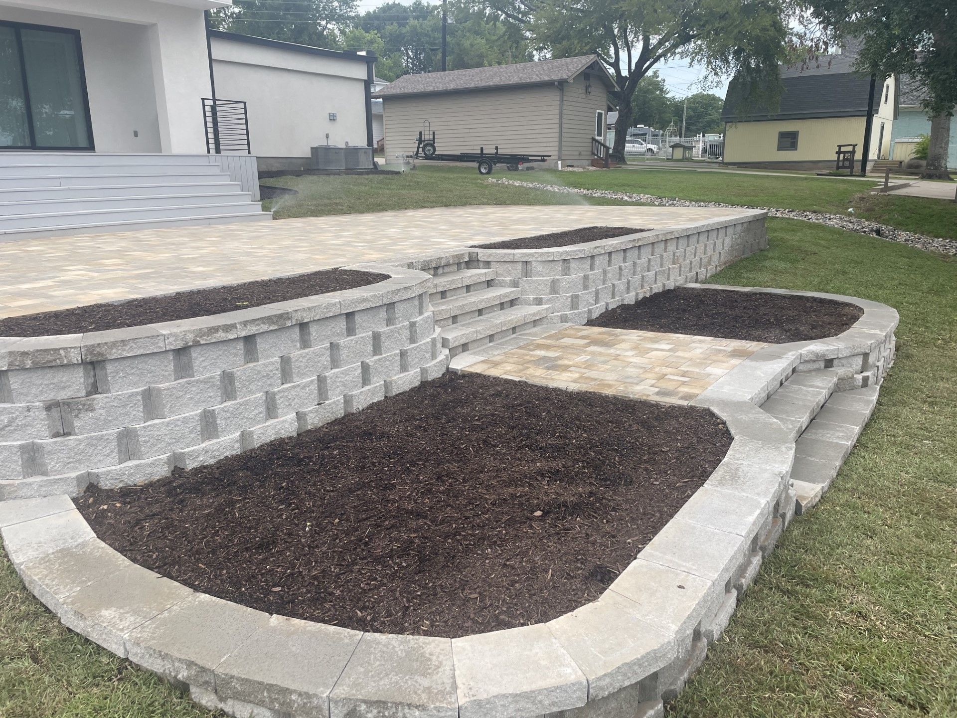 A brick wall with planters in front of a house.