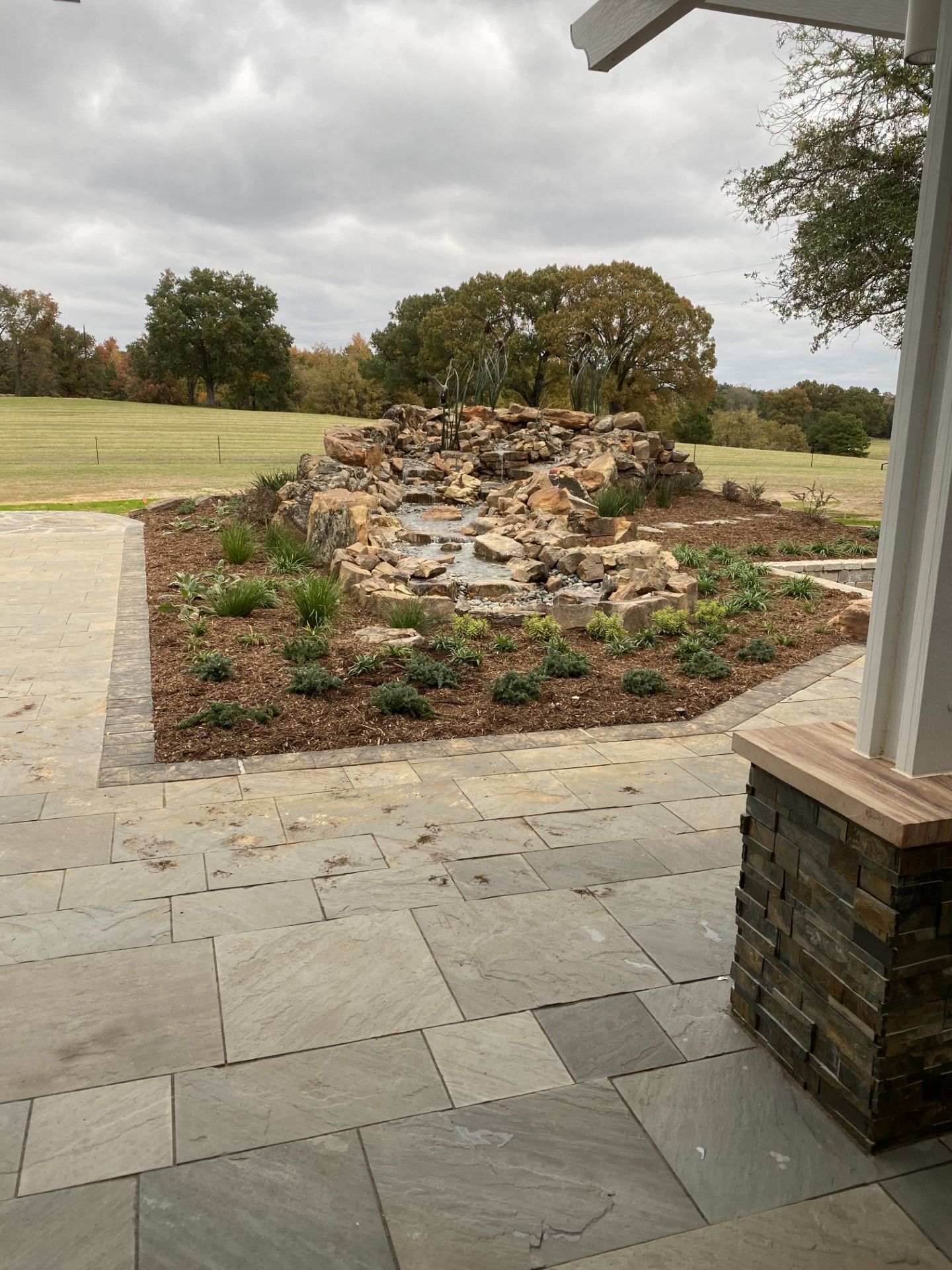 There is a waterfall in the middle of the yard.