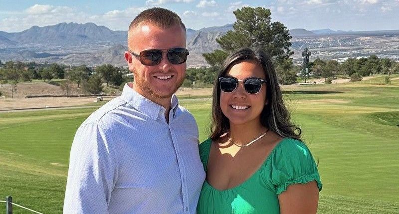 A man and a woman are standing next to each other on a golf course