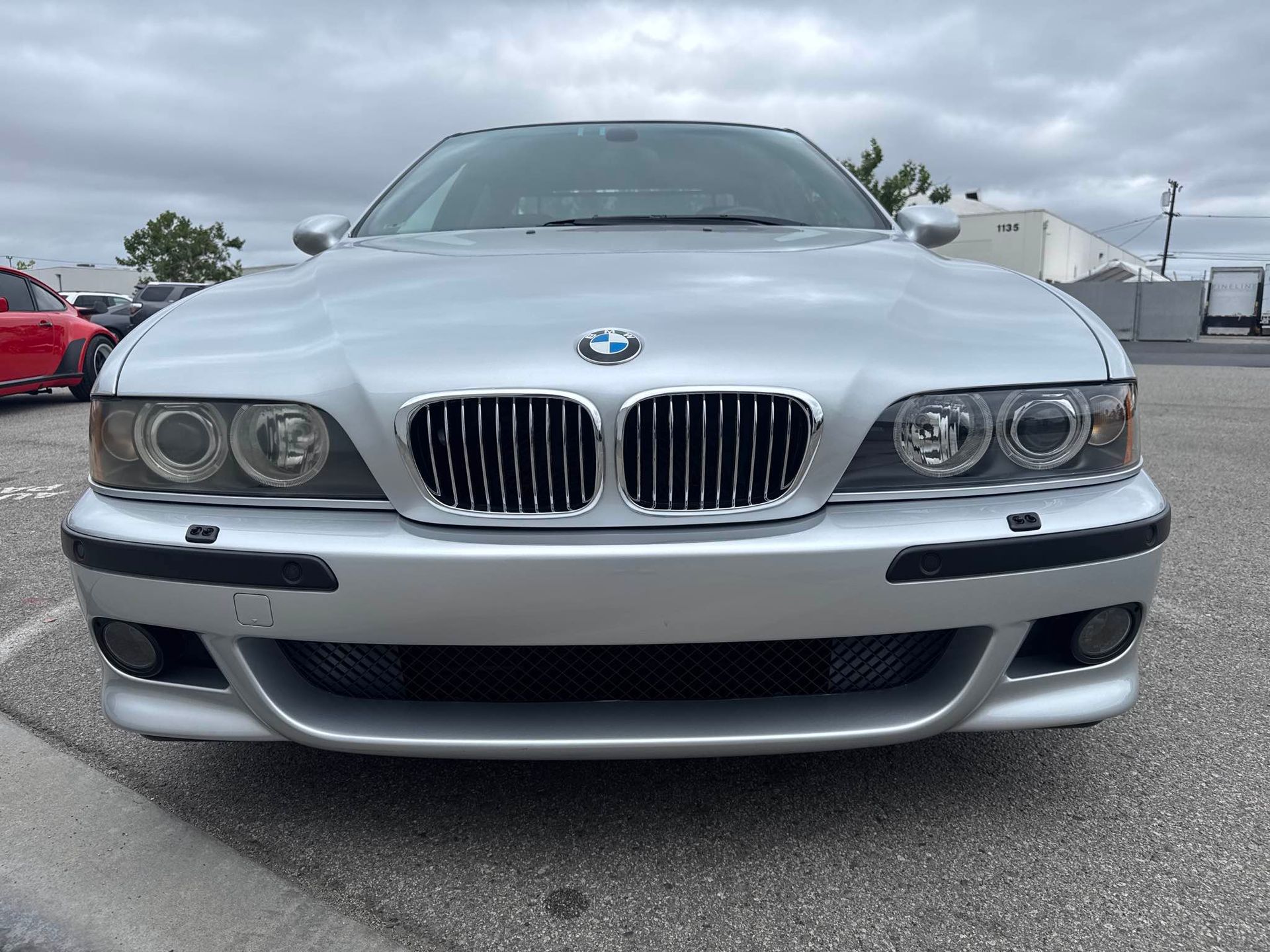 Front view of a silver BMW sedan parked outdoors in a lot