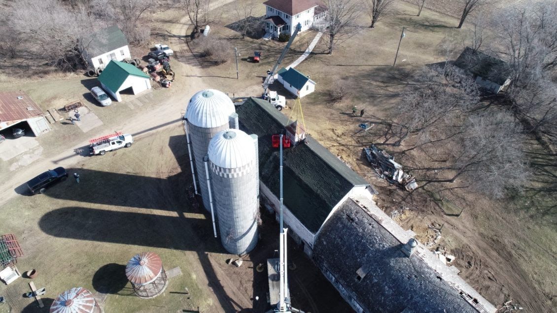 An aerial view of a farm with silos and a crane