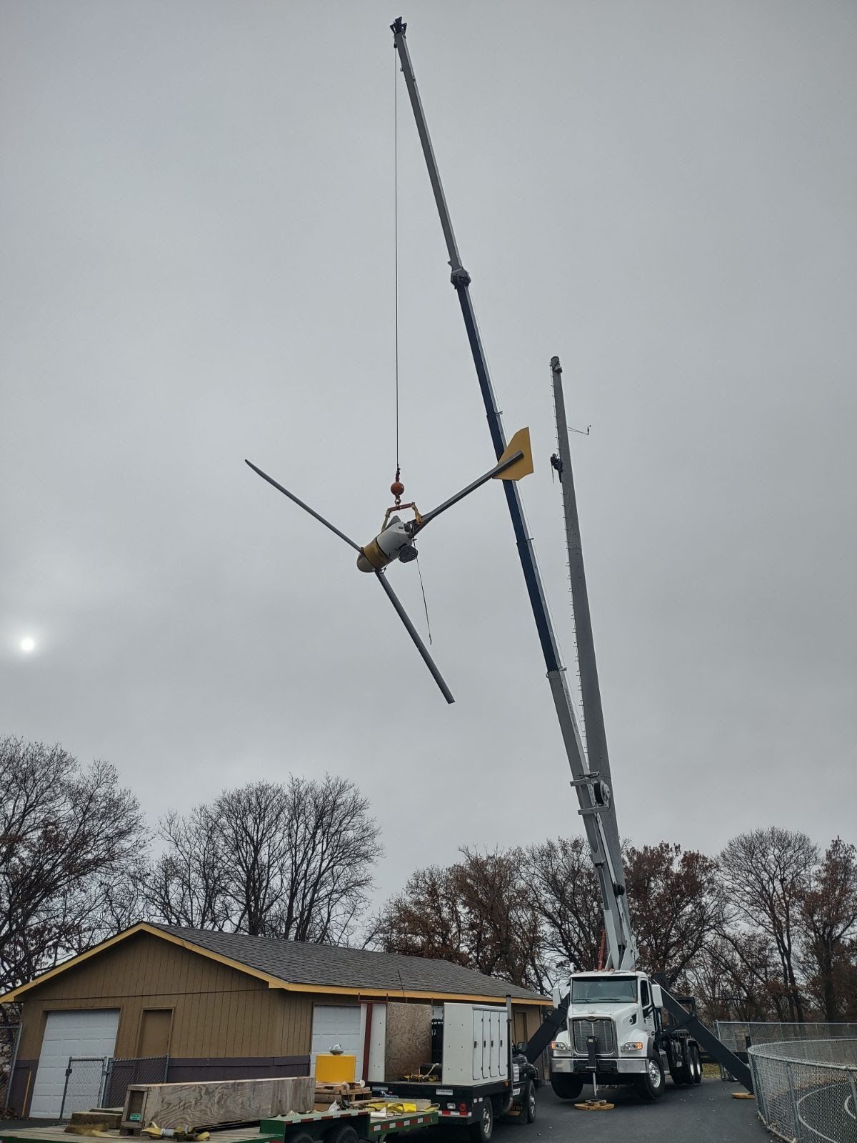 A large crane is lifting a large object over a building