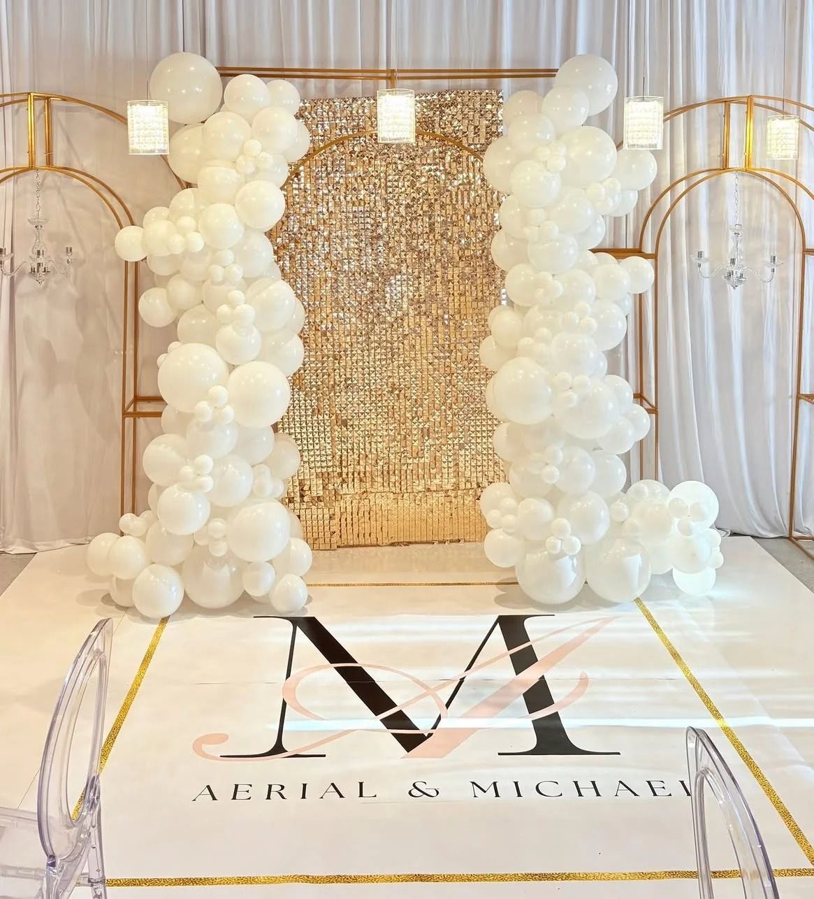 Wedding backdrop with white balloons, gold frame, sequin wall, custom carpet with initials.