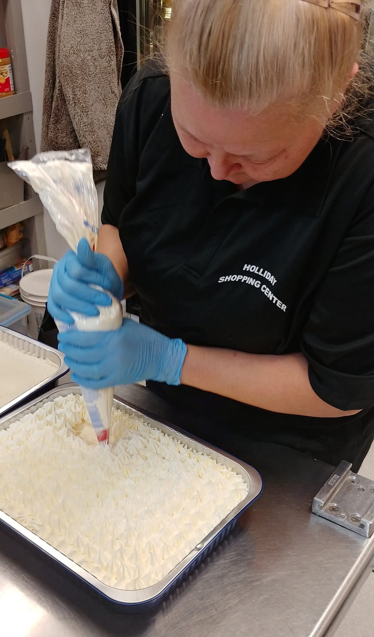 woman putting icing on the cake