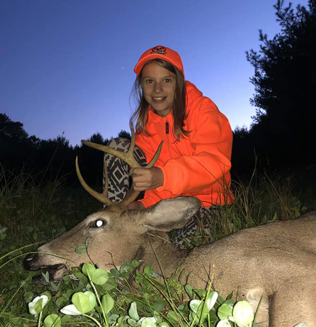 A girl in red jacket holding deer antlers