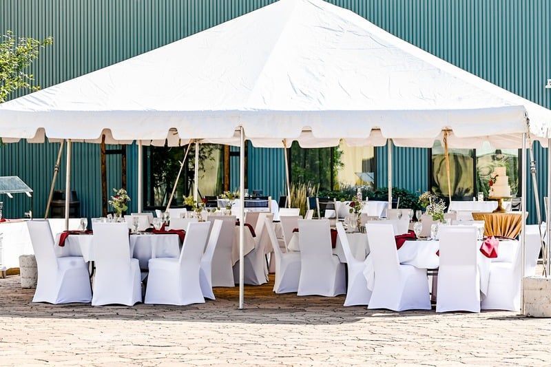 A white tent with tables and chairs underneath it